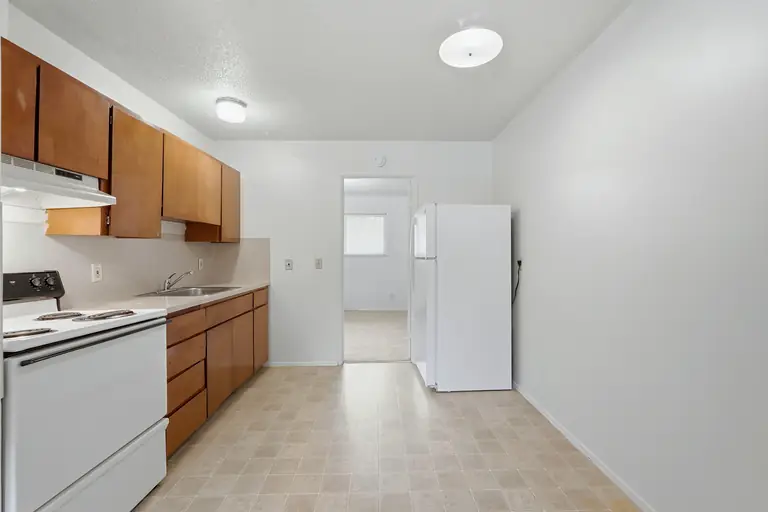 Kitchen with range, cabinets and refrigerator